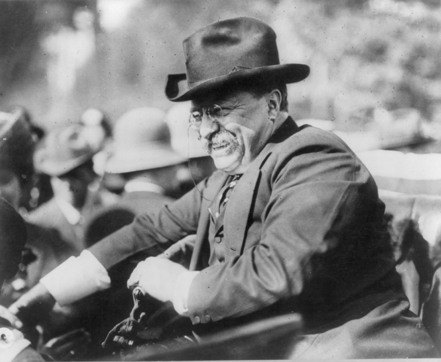 Theodore Roosevelt riding in an early automobile. American Press Association (1910).