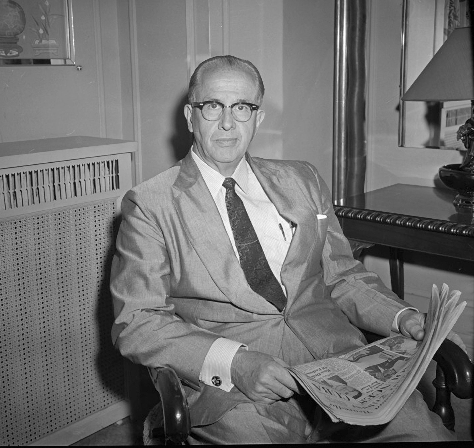 Secretary Ezra Taft Benson, September 1960, taking time to catch up on the news. Utah State Historical Society