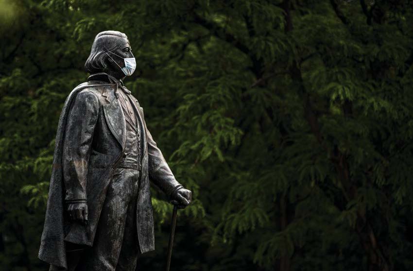 Statue of Brigham Young wearing a mask during the Covid-19 pandemic. Photograph by Nate Edwards/BYU Photo