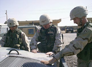 Chaplain Christopher Degn is shown praying over a Humvee he was asked to bless before it “left the wire.” Courtesy of Christopher Degn.