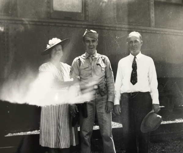 photo of sergeant brown with his parents in front of a train
