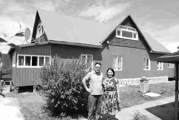 photo of batbayar's home with his wife and son standing outside