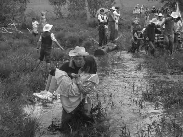 photo of leaders carrying youth through mud on their first trek