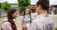 Two sister missionaries sharing a passalong card with a man on the street