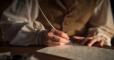 image of Oliver Cowdry writing with a quill pen