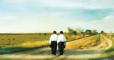 Two missionaries walking in a field